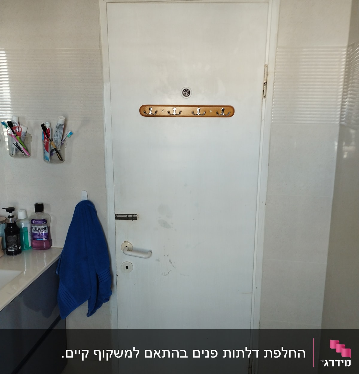 דלת לבנה עם ידית ומתקן לתליית מגבות